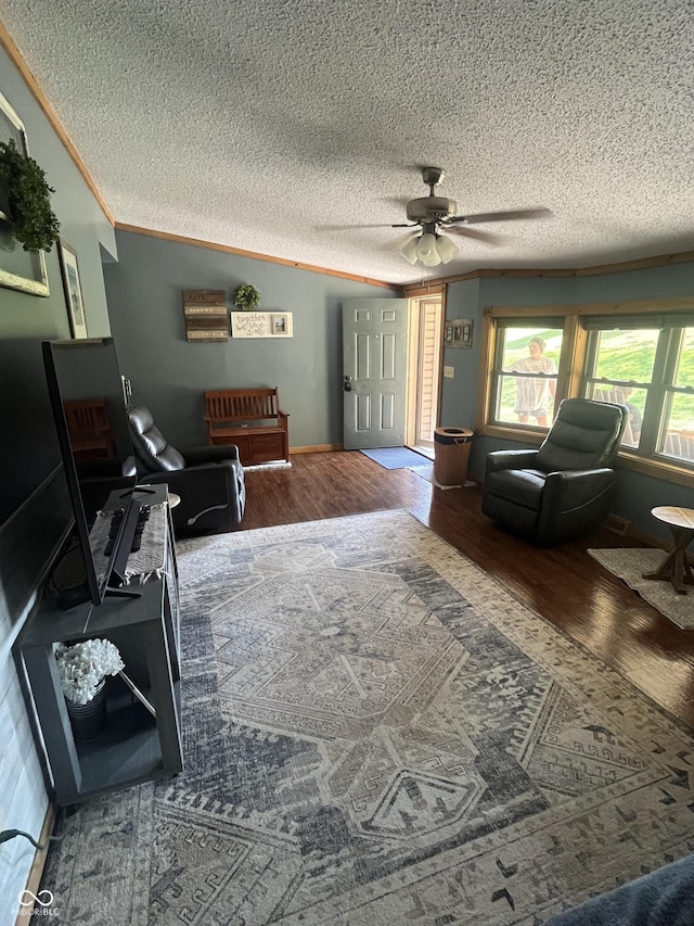 living room featuring crown molding, hardwood / wood-style floors, ceiling fan, and a textured ceiling