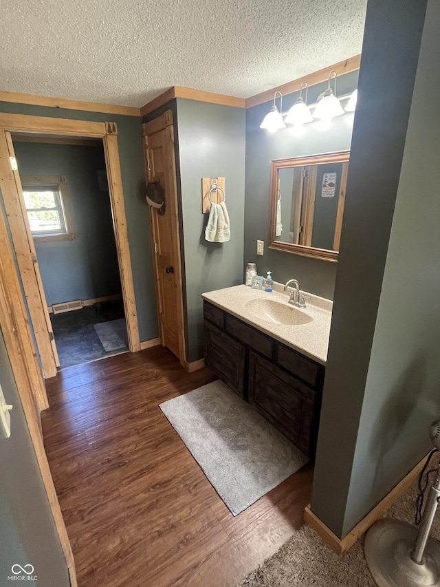 bathroom featuring hardwood / wood-style floors, vanity, and a textured ceiling