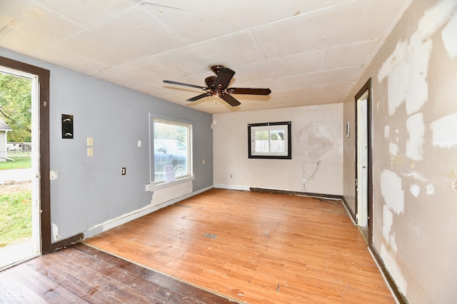 spare room featuring wood-type flooring, ceiling fan, and a healthy amount of sunlight