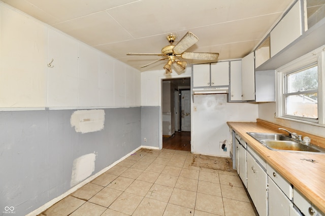 kitchen featuring ceiling fan, sink, and white cabinets