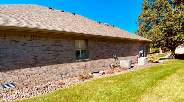 view of home's exterior featuring central AC unit and a lawn