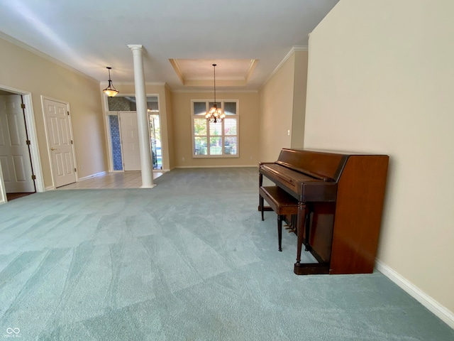 miscellaneous room with a tray ceiling, ornamental molding, decorative columns, a notable chandelier, and light colored carpet