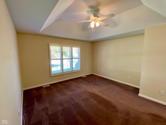 carpeted empty room featuring a tray ceiling and ceiling fan