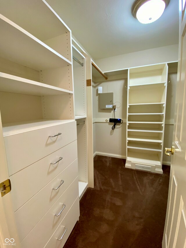 walk in closet featuring dark colored carpet