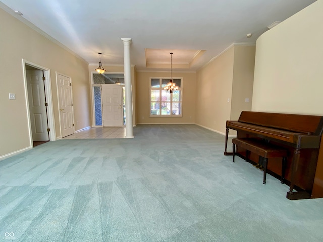 interior space featuring ornamental molding, an inviting chandelier, carpet floors, and decorative columns