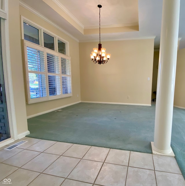 carpeted spare room featuring a notable chandelier, ornamental molding, a tray ceiling, and ornate columns