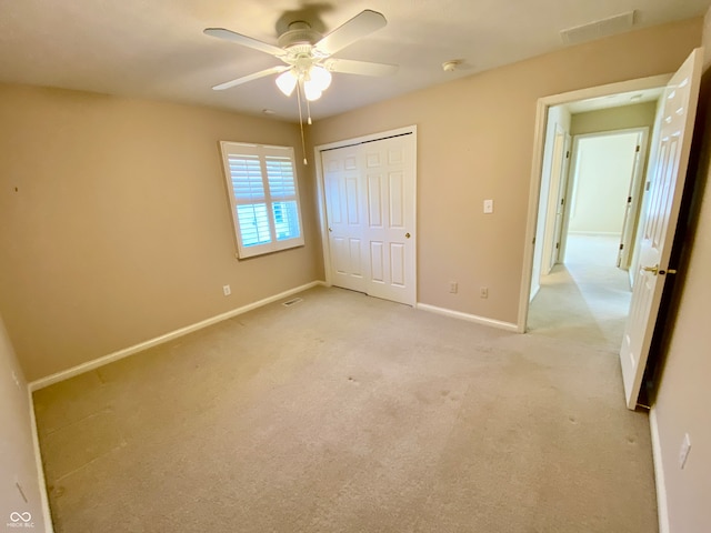 unfurnished bedroom with a closet, ceiling fan, and light carpet