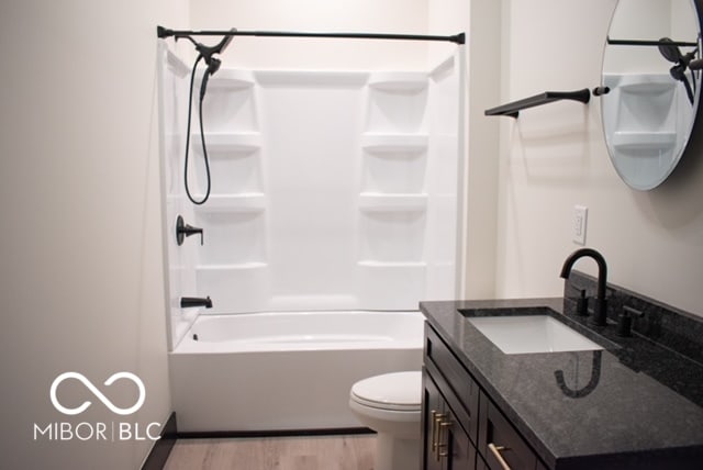 full bathroom featuring vanity, toilet, hardwood / wood-style flooring, and bathing tub / shower combination