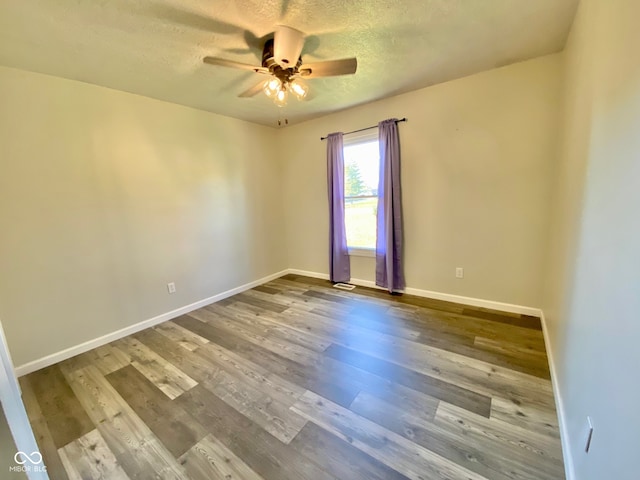 spare room with ceiling fan, wood-type flooring, and a textured ceiling