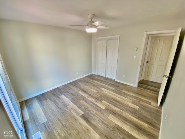 unfurnished bedroom with ceiling fan, a closet, and light wood-type flooring