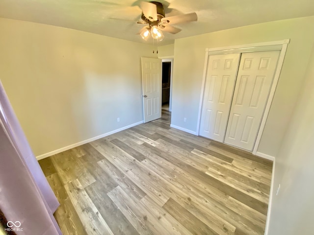 unfurnished bedroom with light hardwood / wood-style floors, a closet, and ceiling fan