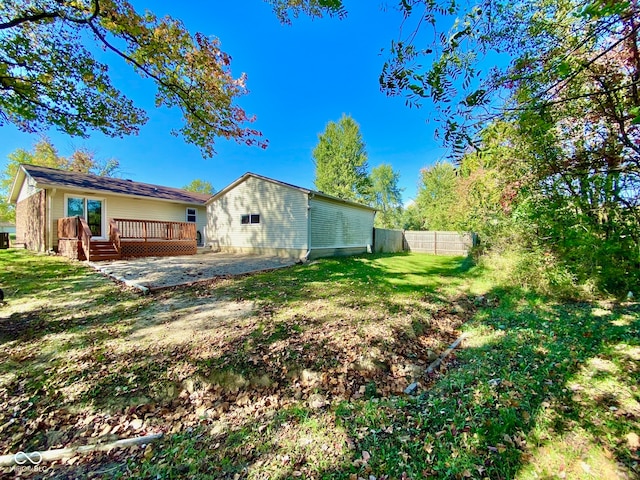 exterior space with a patio, a lawn, and a wooden deck