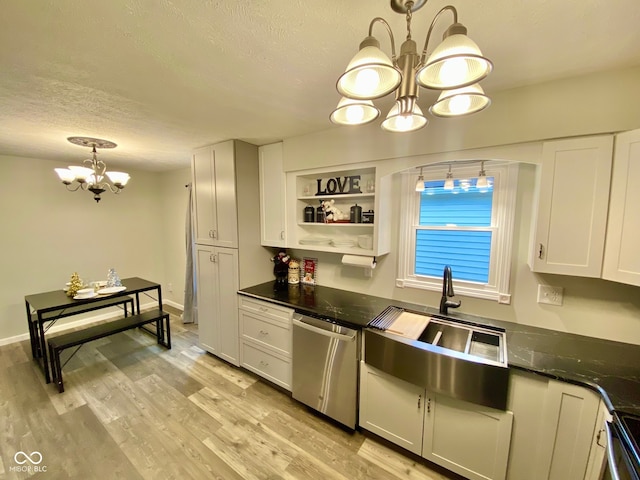 kitchen featuring white cabinetry, hanging light fixtures, stainless steel appliances, light hardwood / wood-style flooring, and a chandelier