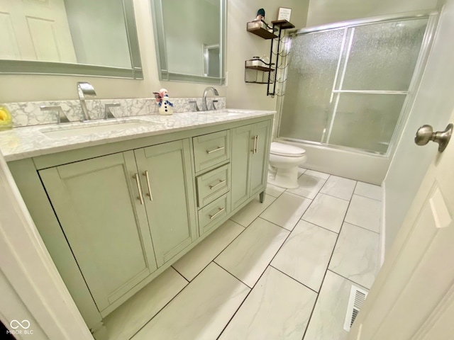 full bathroom with tile patterned flooring, vanity, toilet, and shower / bath combination with glass door