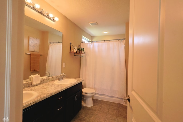 full bathroom with vanity, shower / bath combo with shower curtain, toilet, and a textured ceiling