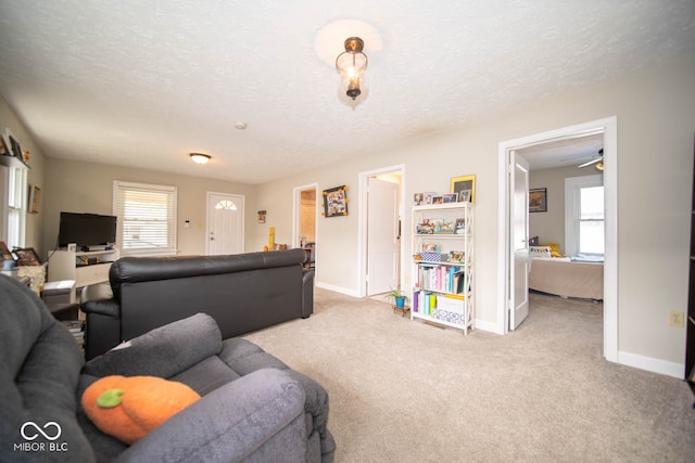 carpeted living room with a textured ceiling and ceiling fan