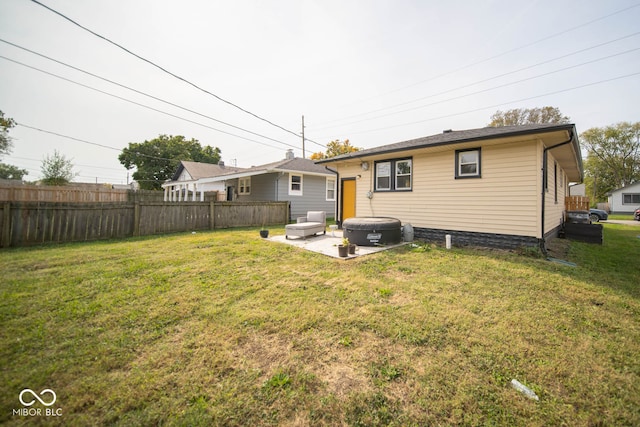 rear view of property featuring a patio and a yard