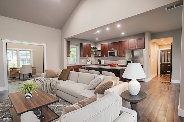 living room featuring high vaulted ceiling, dark hardwood / wood-style flooring, and sink