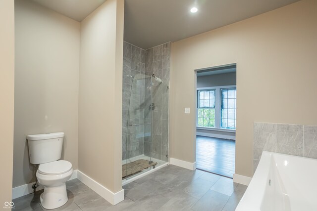 bathroom featuring independent shower and bath, tile patterned floors, and toilet