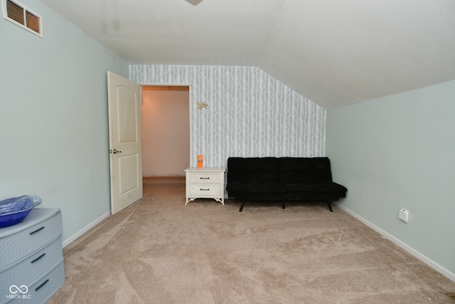 sitting room with vaulted ceiling and light carpet