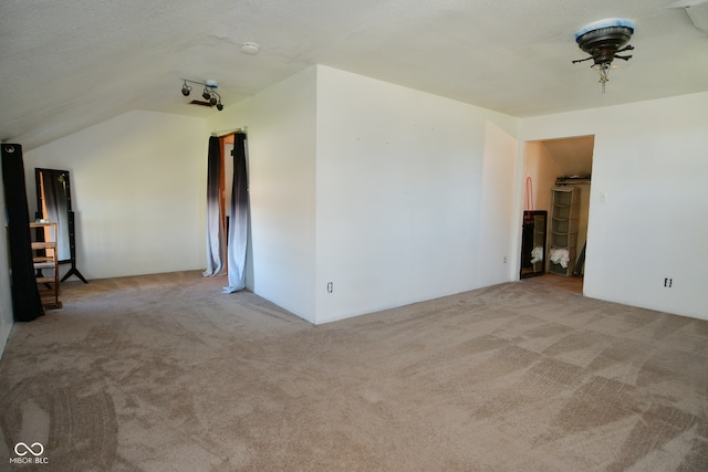 carpeted empty room with lofted ceiling and a textured ceiling