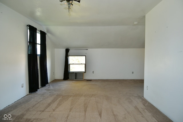 carpeted spare room featuring vaulted ceiling