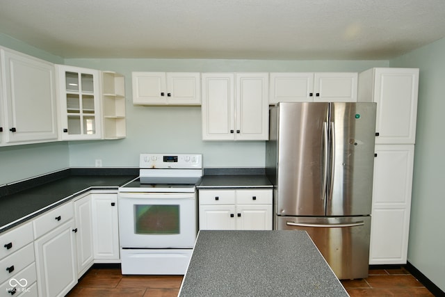 kitchen featuring electric stove, stainless steel refrigerator, and white cabinets