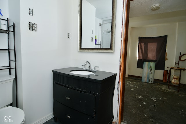 bathroom with toilet, concrete floors, a textured ceiling, and vanity