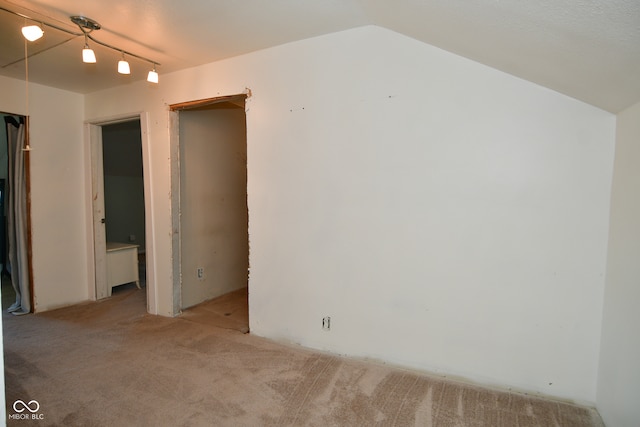 carpeted empty room featuring lofted ceiling