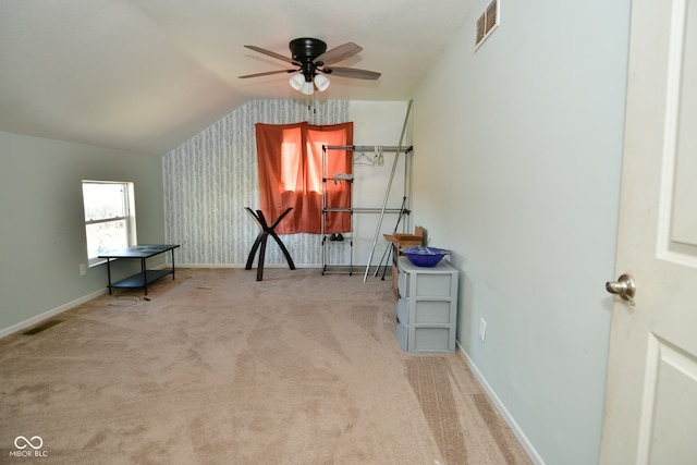 interior space featuring light carpet, vaulted ceiling, and ceiling fan