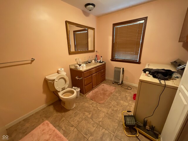 bathroom with washer / dryer, toilet, vanity, and radiator