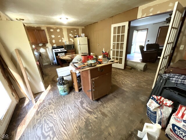 kitchen with french doors, ceiling fan, a kitchen island, and white appliances