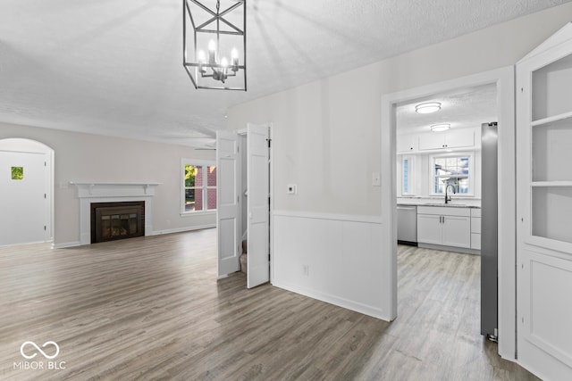 unfurnished living room featuring hardwood / wood-style floors, a textured ceiling, and a wealth of natural light