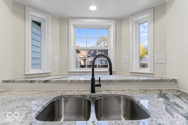 room details featuring light stone countertops and sink