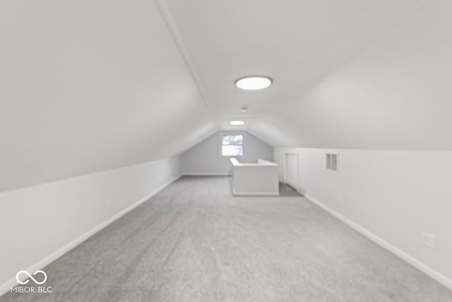 bonus room with carpet floors and vaulted ceiling