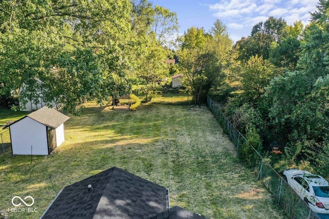 view of yard featuring a storage unit and a playground