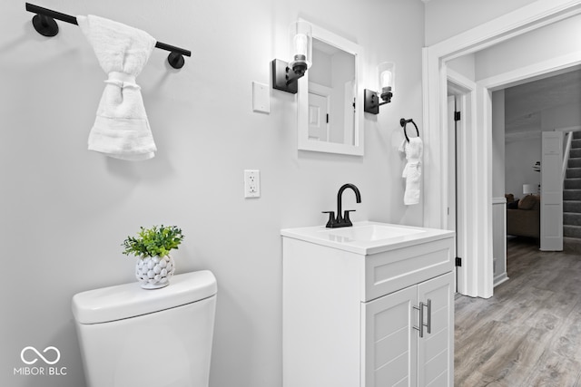 bathroom featuring vanity, hardwood / wood-style floors, and toilet