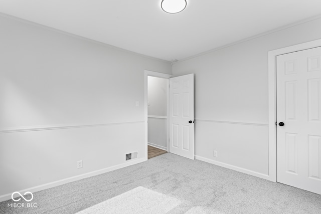 unfurnished bedroom with crown molding and carpet