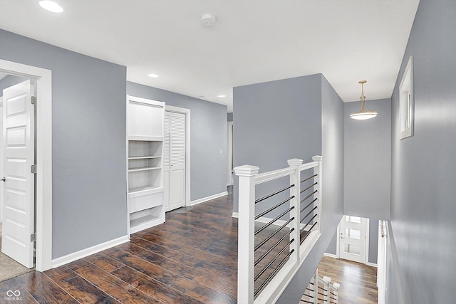 hall with built in shelves and dark hardwood / wood-style floors