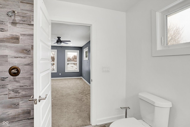 bathroom with toilet, ceiling fan, and a shower