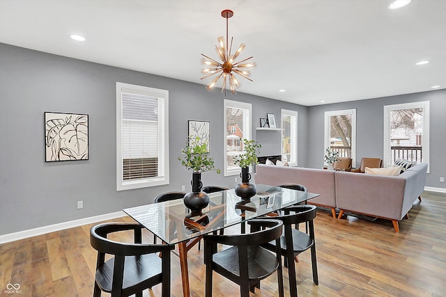 dining area with wood-type flooring and a chandelier