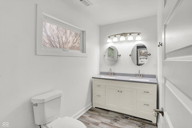 bathroom featuring toilet, vanity, and hardwood / wood-style floors