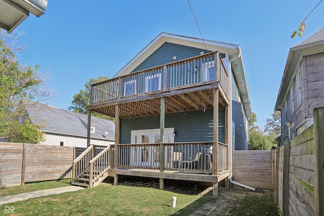 back of house featuring a deck and a lawn