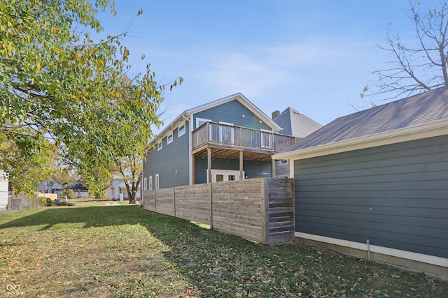 rear view of property with a balcony and a lawn