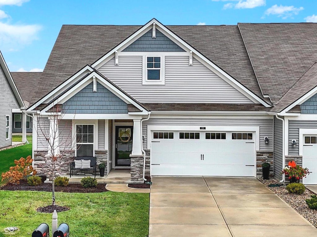 craftsman-style home featuring a front yard, a porch, and a garage