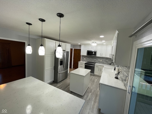 kitchen with hardwood / wood-style flooring, hanging light fixtures, stainless steel appliances, a center island, and white cabinets