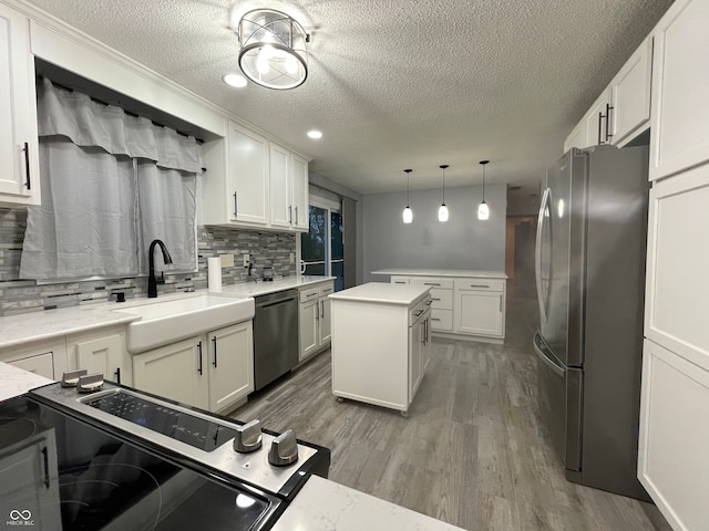 kitchen with hardwood / wood-style floors, sink, light stone countertops, appliances with stainless steel finishes, and tasteful backsplash