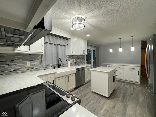 kitchen featuring appliances with stainless steel finishes, light wood-type flooring, decorative backsplash, and white cabinets