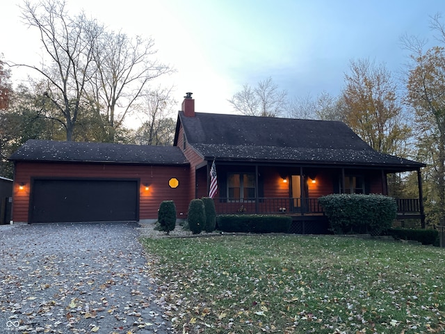 view of front facade with covered porch, a front yard, and a garage