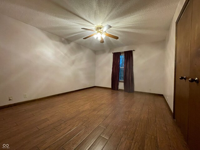 bonus room featuring a textured ceiling, dark wood-type flooring, and ceiling fan